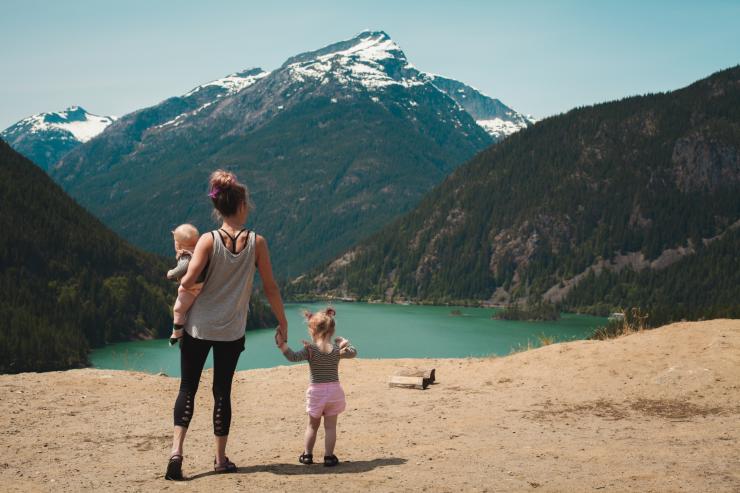 Mamma e due figli in vacanza, di fronte a un lago.
